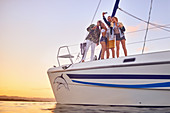 Friends taking selfie on catamaran at sunset