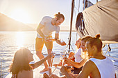 Friends drinking champagne on sunny catamaran