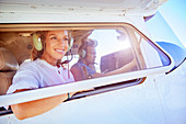 Smiling woman riding in small airplane