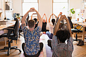 Creative business people practicing yoga in office