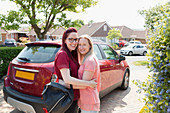 Lesbian couple hugging in driveway
