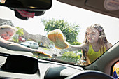 Mother and daughter washing car windshield