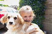 Happy girl hugging dog