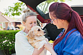 Lesbian couple and dog in driveway