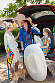 Lesbian couple and daughter loading the car