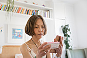 Senior woman with smart phone looking medicine