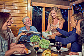 Woman serving dinner to friends at cabin