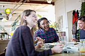 Happy Roommates eating take out food in apartment