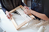 Women friends assembling string frame art