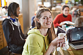 Young woman drinking coffee with roommates