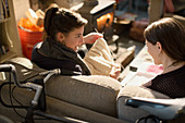 Young women roommates knitting on living room sofa