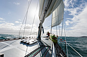 Woman at bow of sailboat on sunny ocean