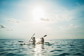 Women in clear bottom canoe on idyllic ocean