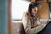 Teenage girl texting in motor home