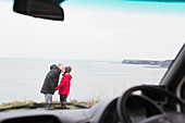 Couple kissing outside motor home on cliff