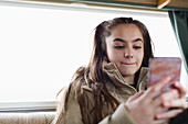 Teenage girl texting with smart phone