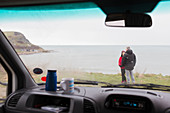 Couple talking outside motor home on cliff