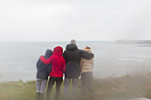 Family in warm clothing enjoying ocean view
