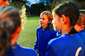 Attentive girls soccer team listening to coach