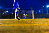 Girl soccer player kicking ball toward goal