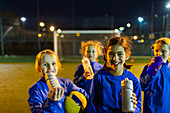Portrait smiling girls soccer team taking a break