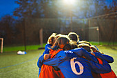 Girls soccer team huddling