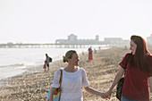 Lesbian couple holding hands on beach