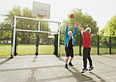 Active senior men friends playing basketball