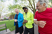 Active senior men friends power walking in park