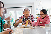 Grandfather and granddaughter sharing noodles