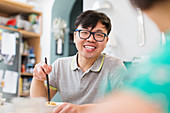 Happy man eating noodles with chopsticks