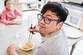 Portrait man eating noodles with chopsticks