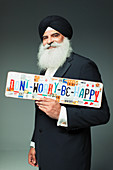 Man in turban holding license plates