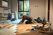 Construction worker laying hardwood flooring