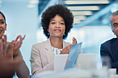 Confident businesswoman clapping in meeting