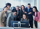 Business people meeting around computer in office