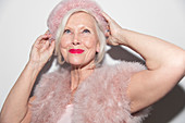Portrait glamorous senior woman wearing pink fur
