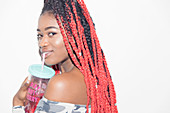 Young woman with long braids drinking juice