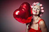 Senior woman holding heart-shape balloon
