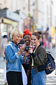 Young women friends using digital camera