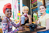 Young women friends drinking smoothies