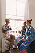 Young women friends talking and drinking tea