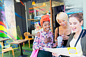 Young women friends with map outside smoothie shop