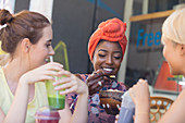 Young women friends drinking smoothies and eating