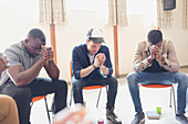 Men praying with rosaries in prayer group
