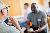 Men talking and listening in group therapy