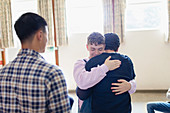 Men hugging in group therapy