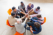 Men joining hands in circle in prayer group