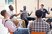 Men with bibles praying with arms outstretched