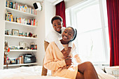 Portrait affectionate mother and son hugging on bed